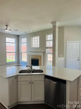 a kitchen with granite countertop white cabinets and a fireplace