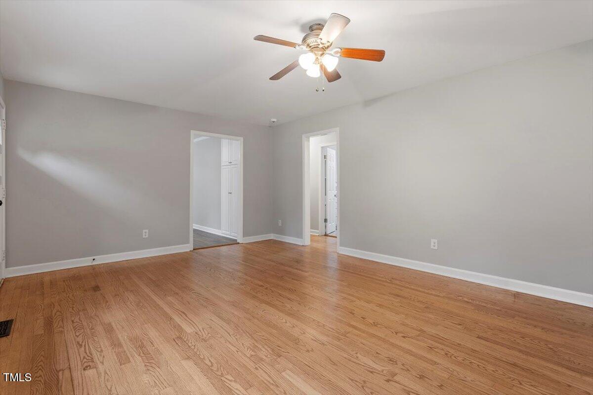 3402 Pat Tilley Road Bahama, NC 27503 - Photo 11 of 32 a view of an empty room with chandelier fan and wooden floor