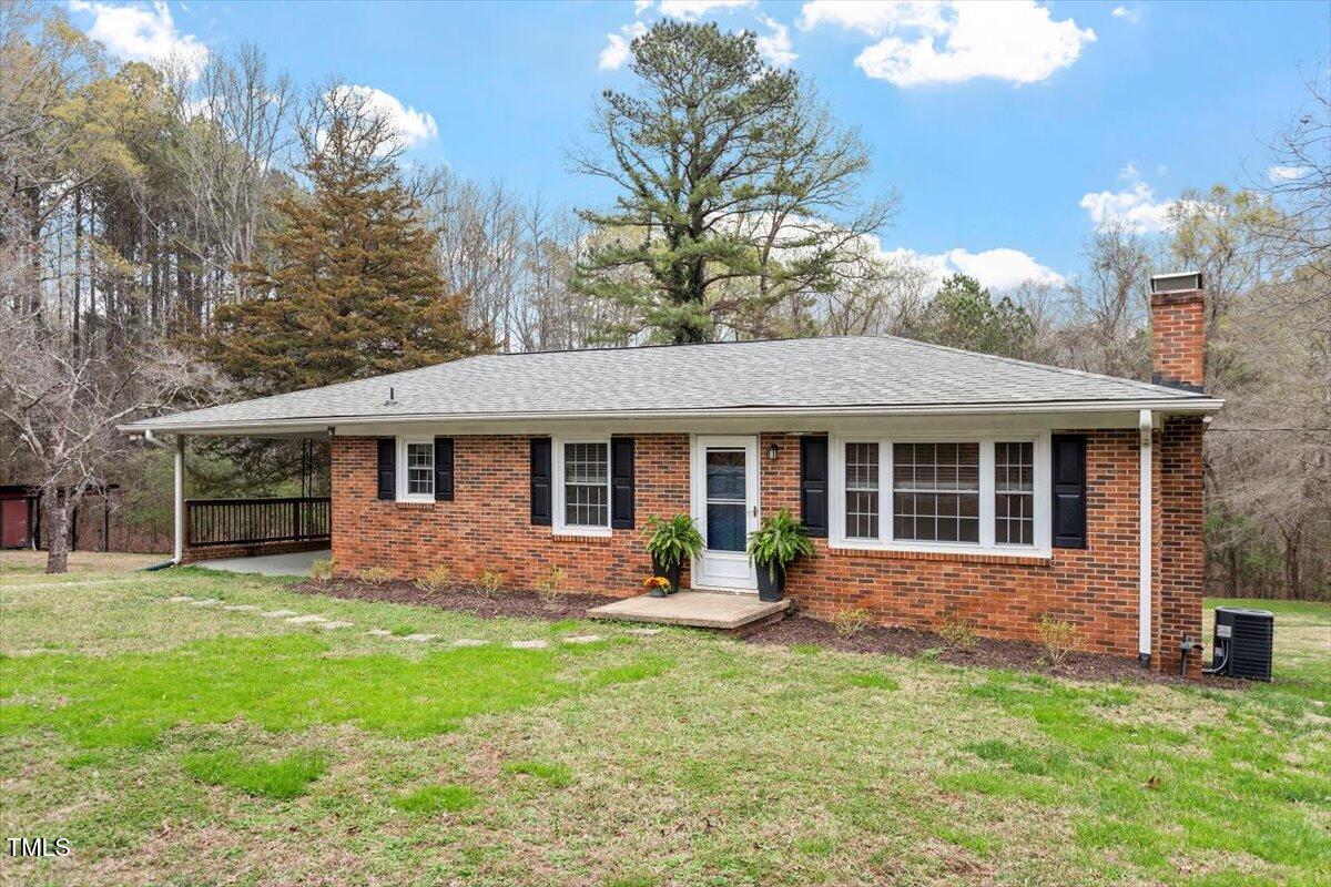 3402 Pat Tilley Road Bahama, NC 27503 - Photo 3 of 32 a front view of a house with a yard and trees