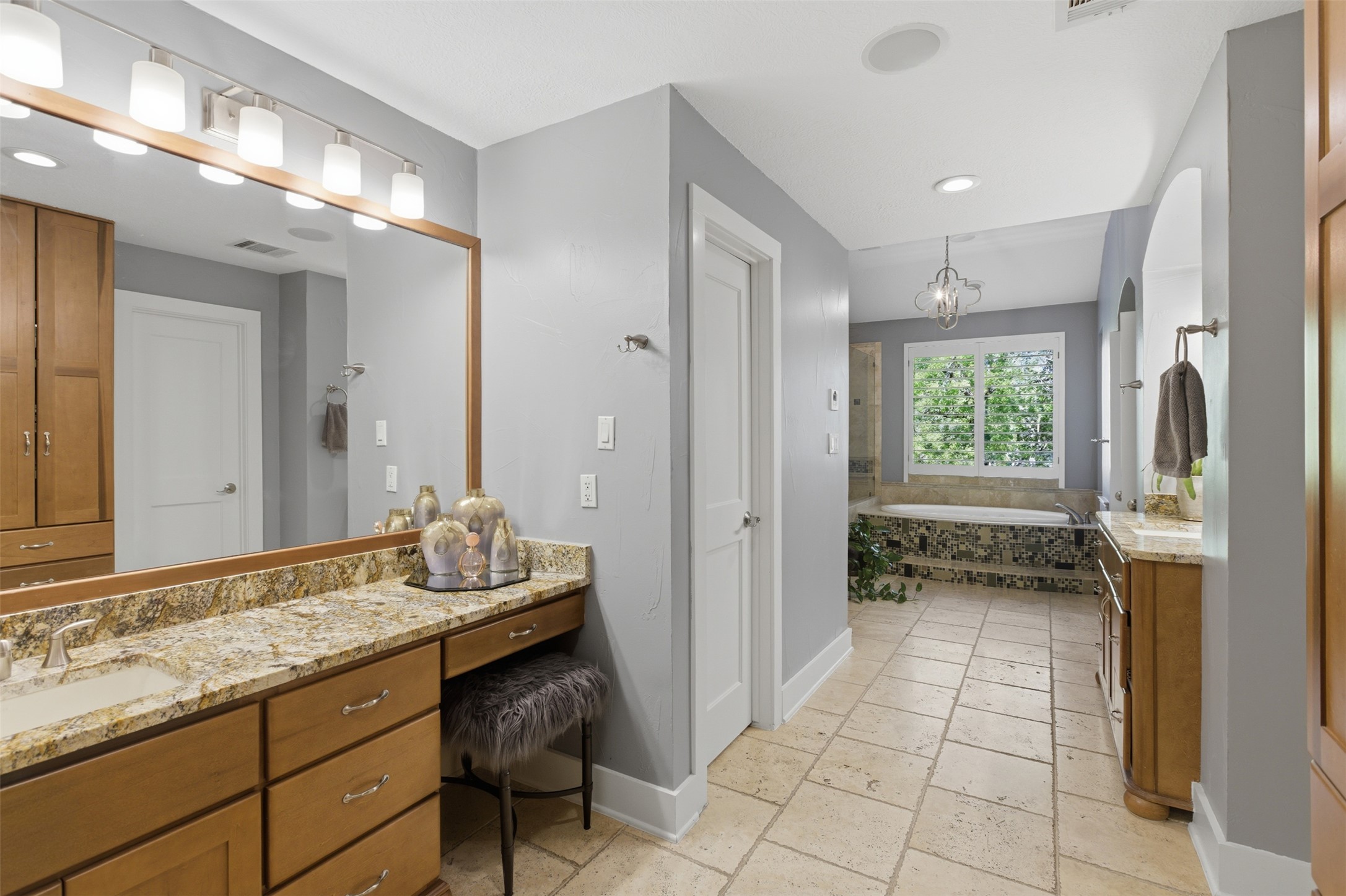 2008 Key West Cove Austin, TX 78746 - Photo 12 of 33 Bathroom with stone tile floors, 2 vanities, a garden jet tub, walk-in shower and laundry room.