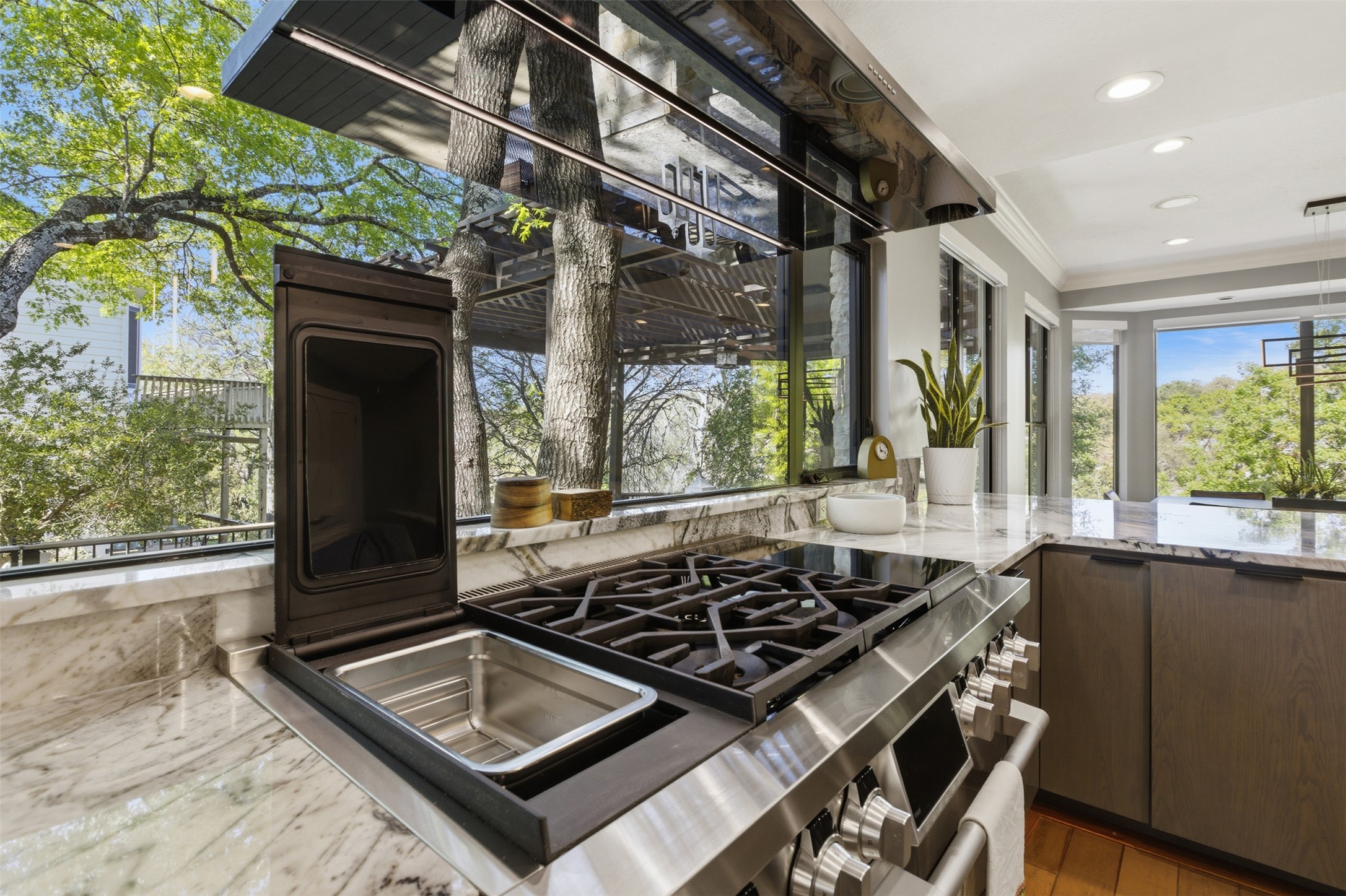 2008 Key West Cove Austin, TX 78746 - Photo 5 of 33 Kitchen with quartzite counters, Signature Kitchen appliances with two ovens, gas/induction/sous vide stove top, crown molding, and recessed lighting.