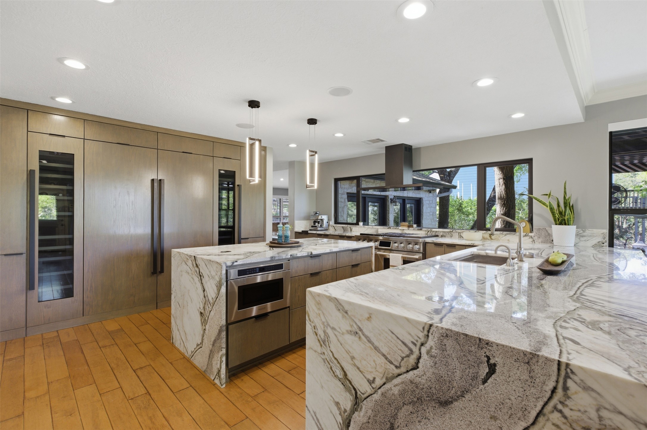2008 Key West Cove Austin, TX 78746 - Photo 7 of 33 Kitchen featuring light wood-style flooring, decorative light fixtures, ventilation hood, and custom wood finish cabinetry