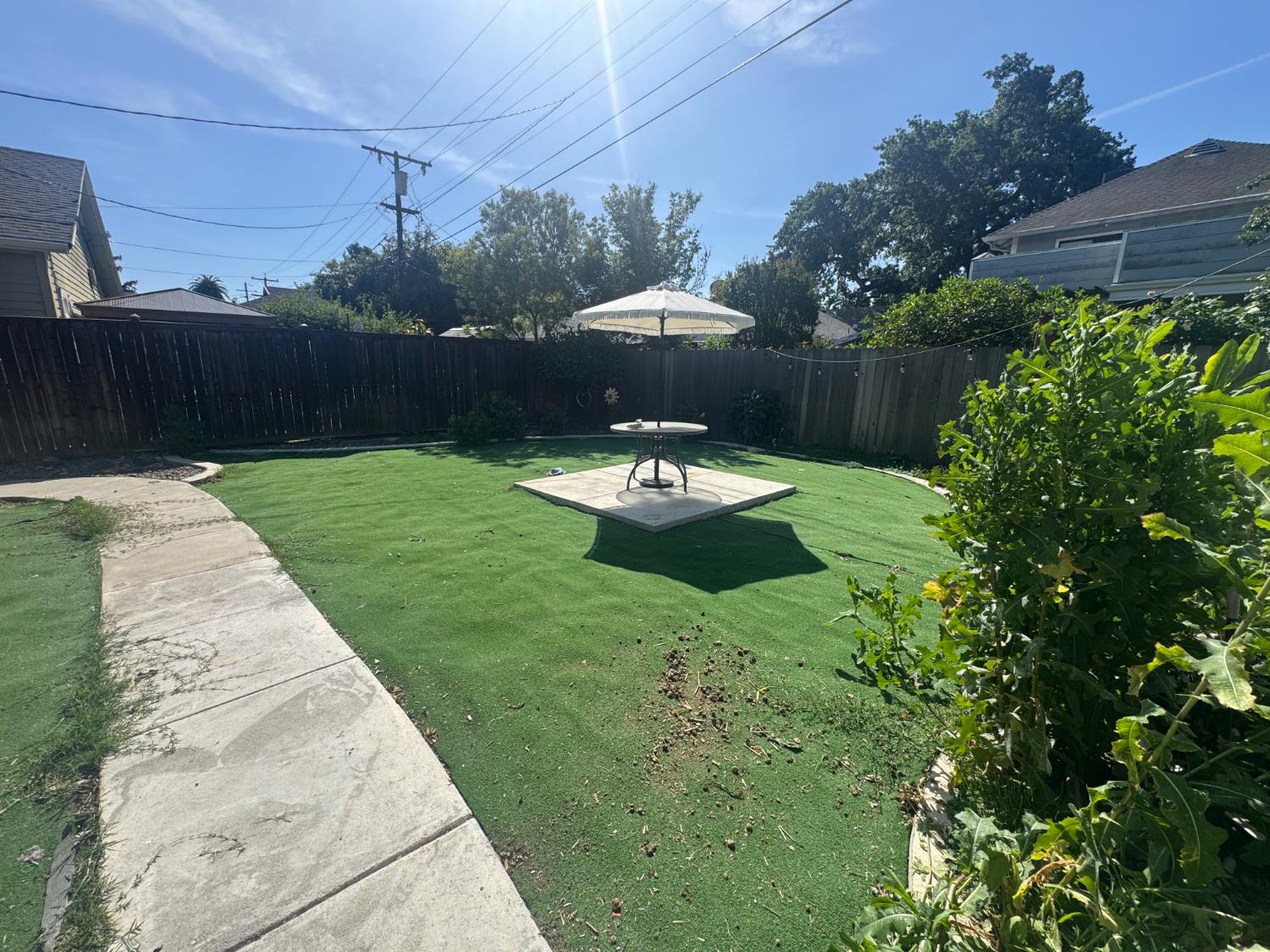1044 West Harding Way Stockton, CA 95203 - Photo 8 of 25 a view of a backyard with table and chairs potted plants and wooden fence
