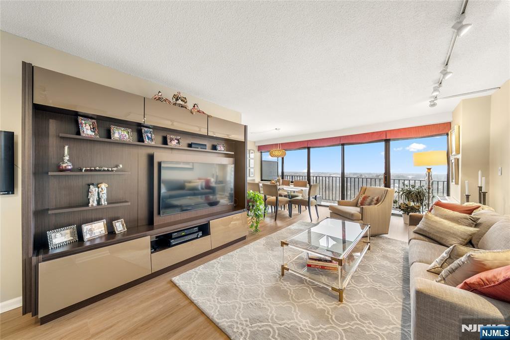 a living room with furniture a flat screen tv and a floor to ceiling window