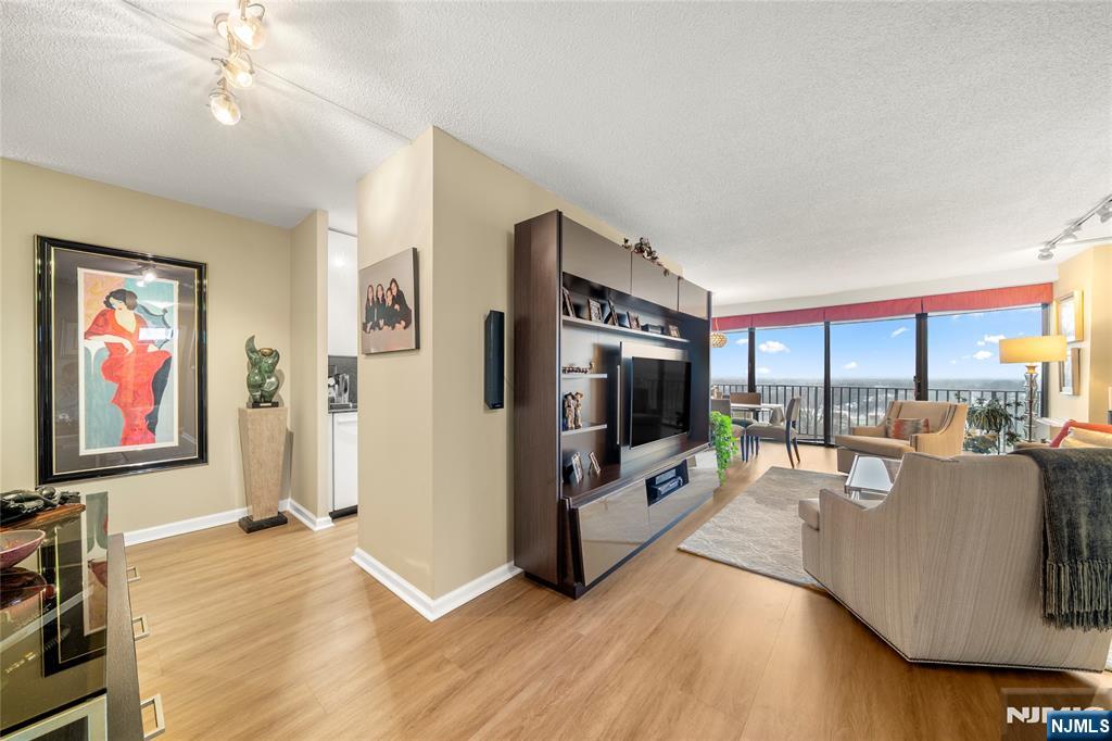 277 Prospect Avenue, Unit 14B Hackensack, NJ 07601 - Photo 2 of 23 a living room with furniture flat screen tv and a fireplace
