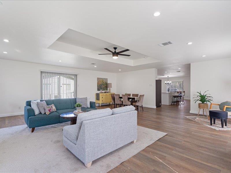1312 Hyman Lane Austin, TX 78742 - Photo 17 of 36 Spacious living area featuring light wood flooring, a tray ceiling with a ceiling fan, recessed lighting, and white walls