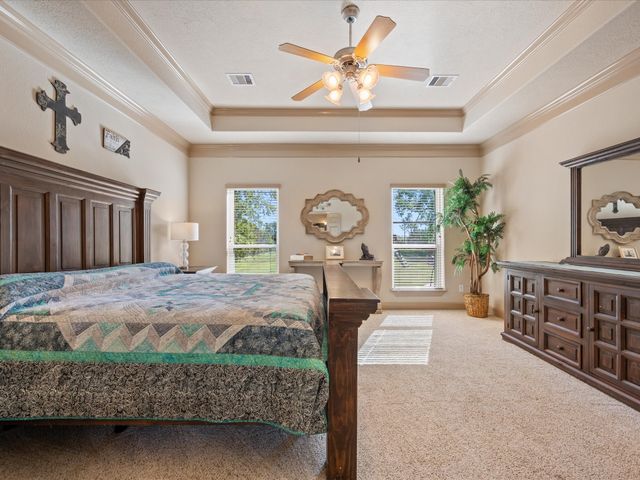 a bedroom with a bed a chandelier and dresser