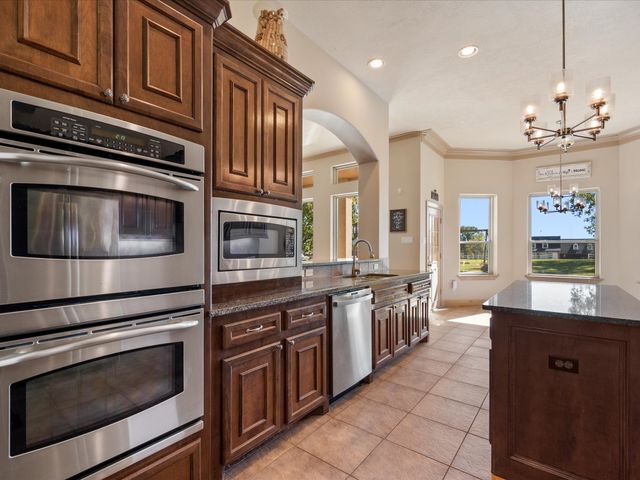 a large kitchen with stainless steel appliances granite countertop a stove and a sink