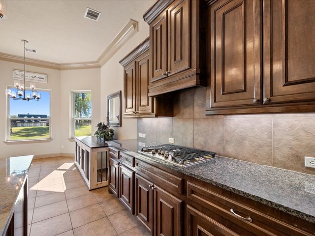 a kitchen with stainless steel appliances granite countertop a stove top oven a sink dishwasher and cabinets with wooden floor