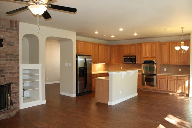 a view of kitchen with refrigerator microwave and stove top oven