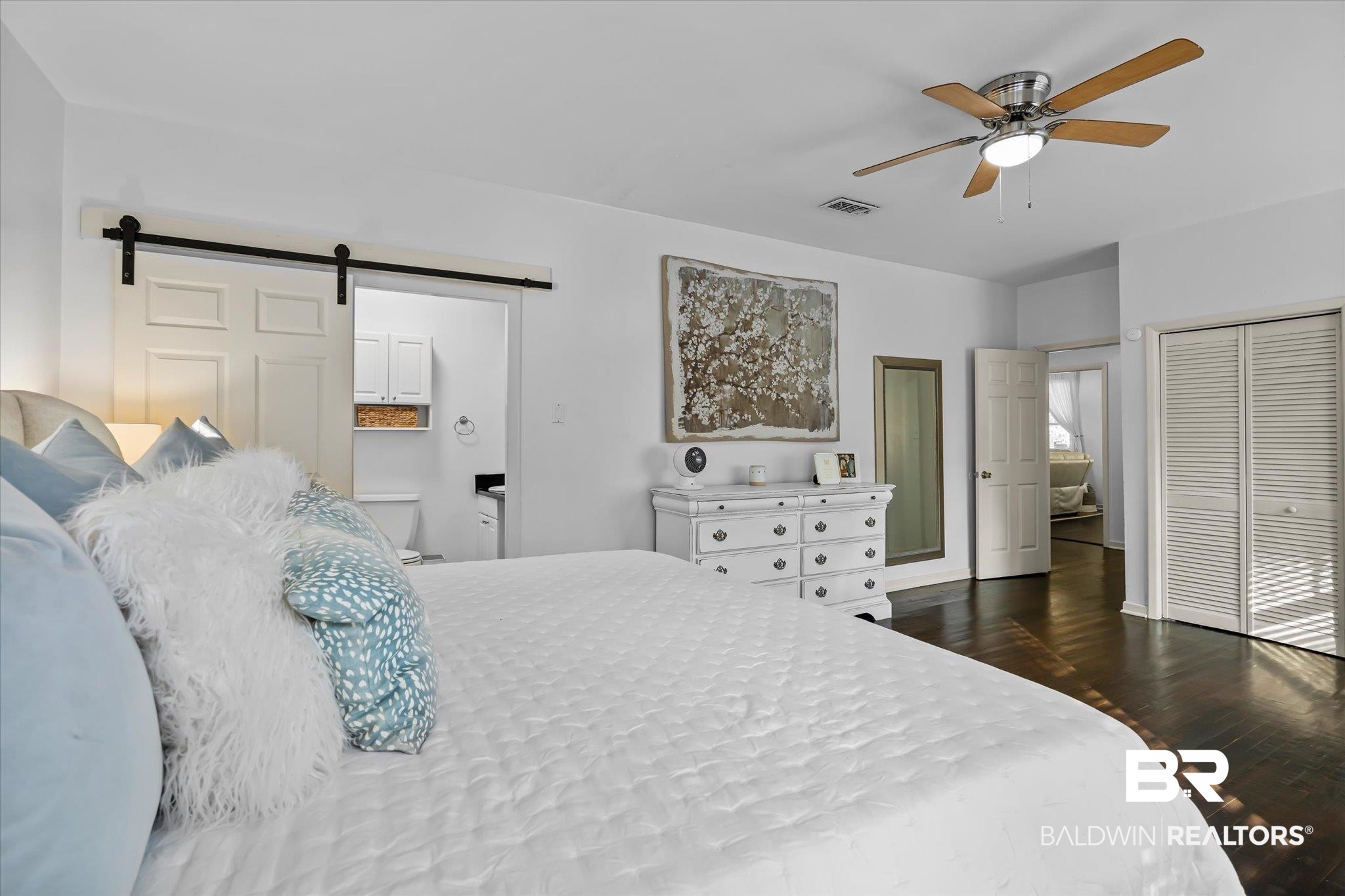 180 Williams Street Mobile, AL 36606 - Photo 12 of 20 Bedroom featuring wood-type flooring, a barn door, ensuite bath, and ceiling fan