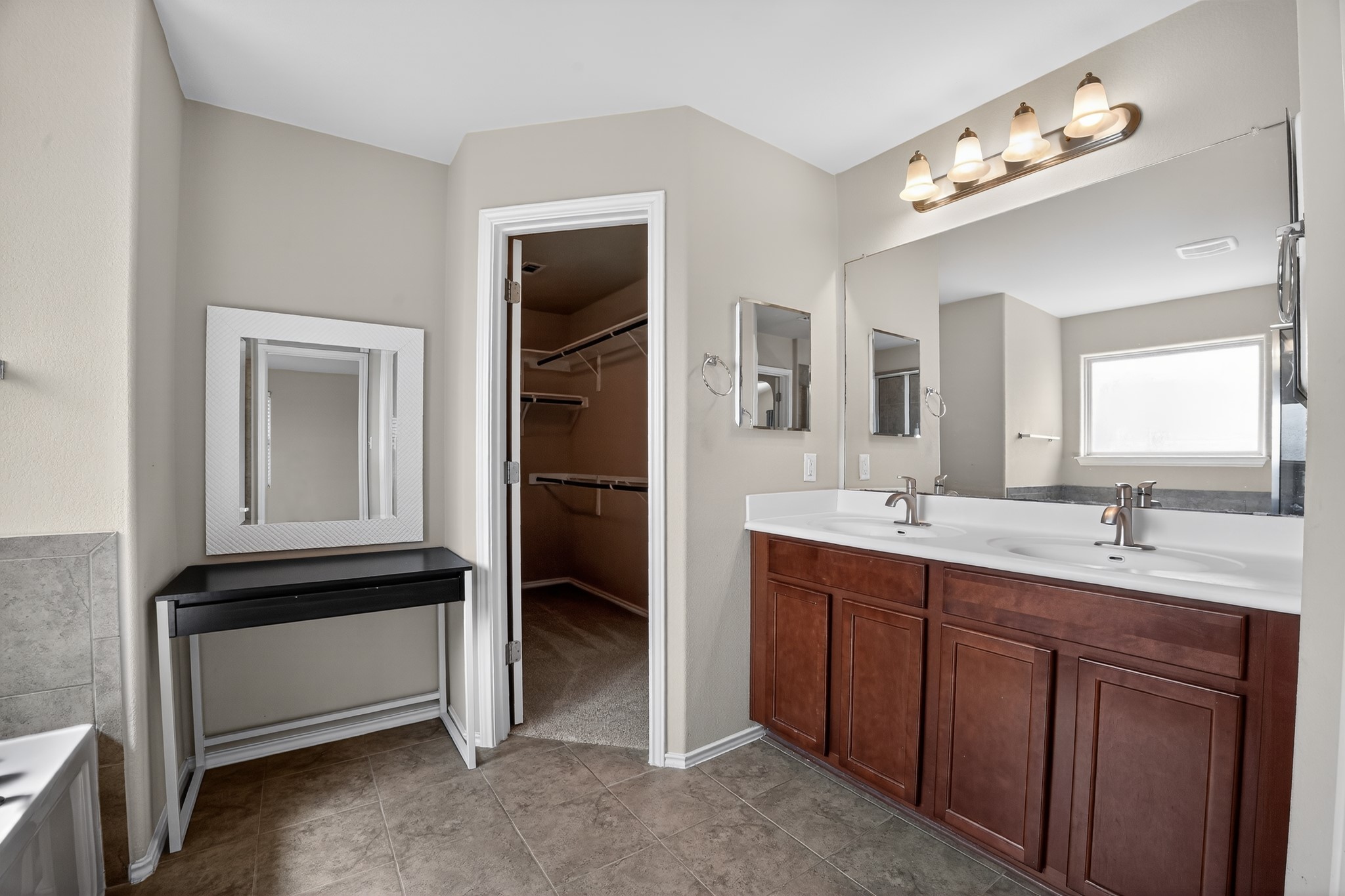 16816 Ruggio Road Pflugerville, TX 78660 - Photo 18 of 30 Indulge in a primary bathroom featuring dual sinks, a large vanity mirror, and direct access to a spacious walk-in closet.