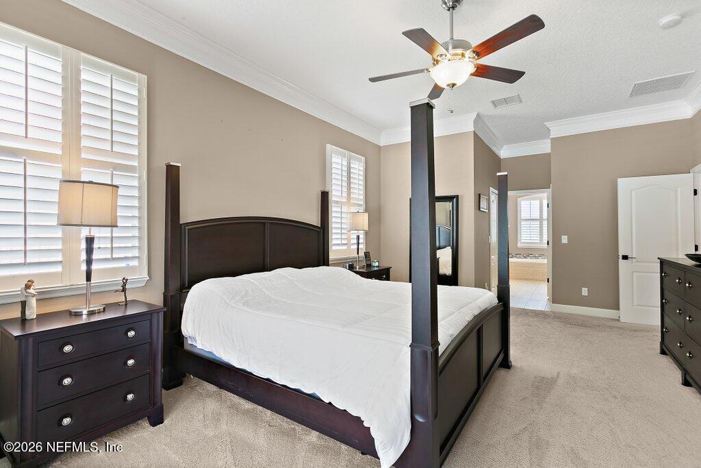 841 Ifield Road St. Augustine, FL 32095 - Photo 25 of 69 a bedroom with a large bed and a chandelier fan