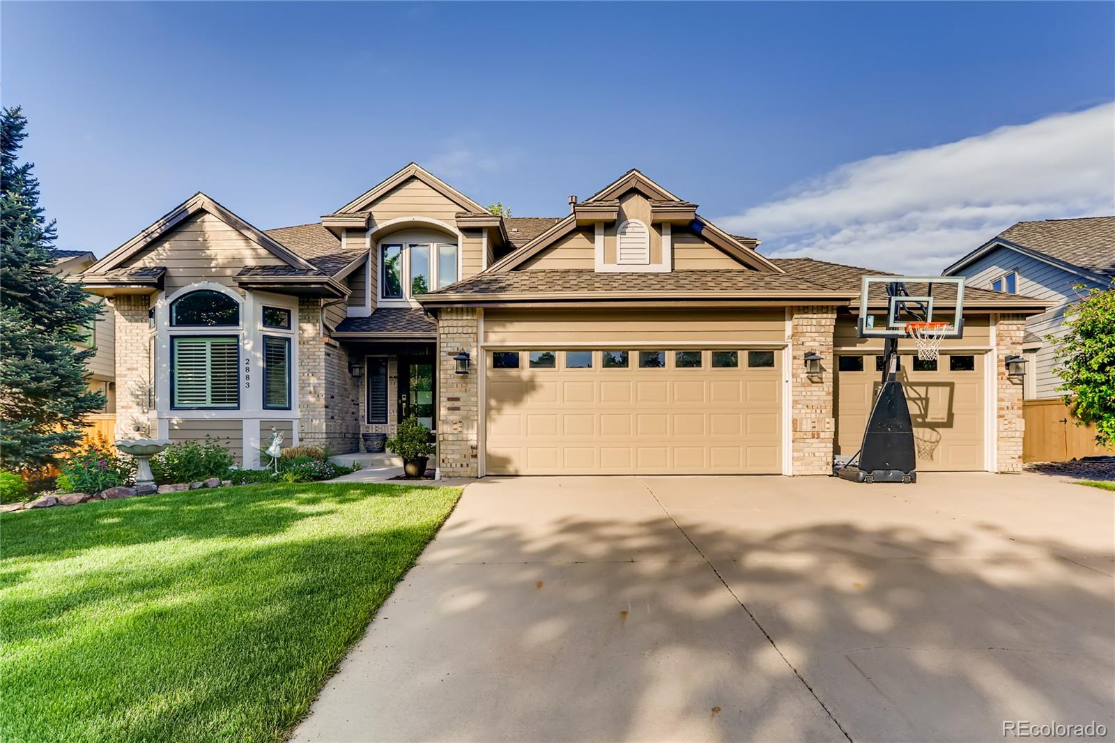 a view of a white house with a big yard and potted plants