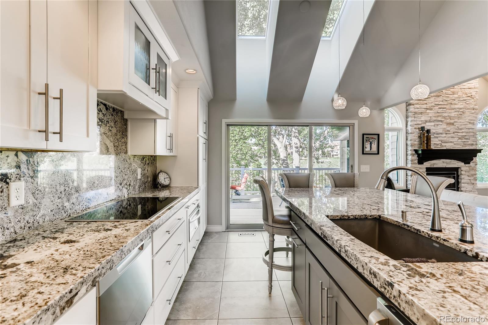 2883 East Ravenhill Circle Highlands Ranch, CO 80126 - Photo 6 of 25 a kitchen with granite countertop a sink a counter top space and stainless steel appliances