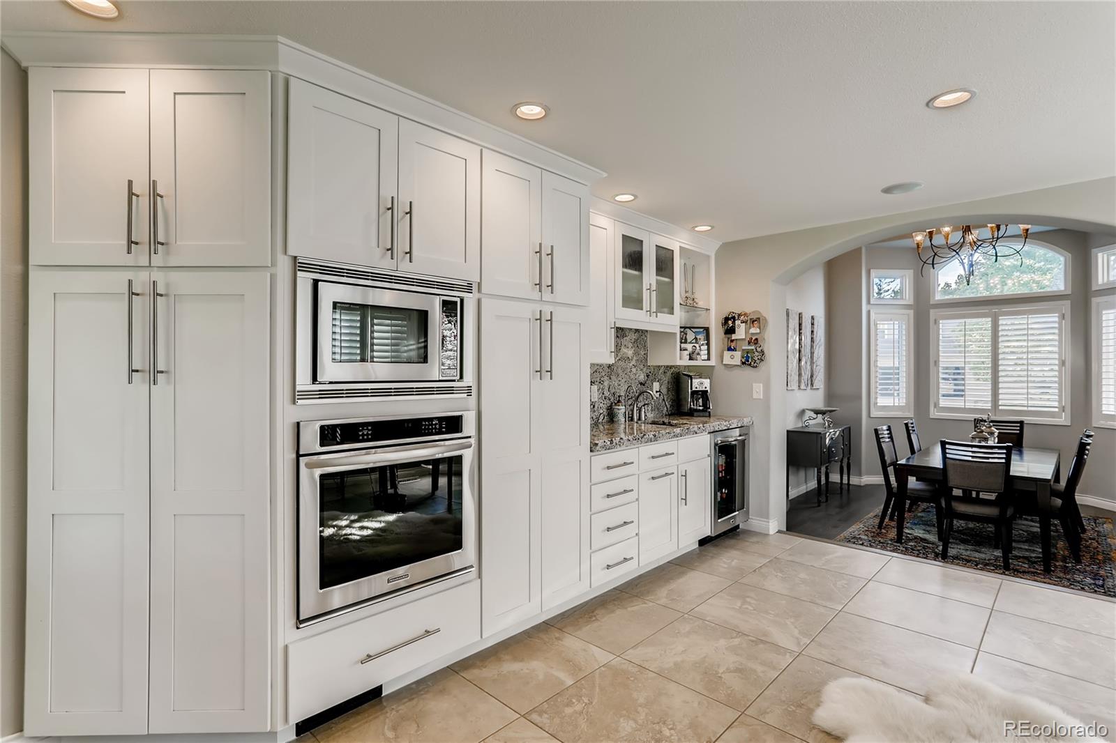 2883 East Ravenhill Circle Highlands Ranch, CO 80126 - Photo 7 of 25 a kitchen with white cabinets and white appliances