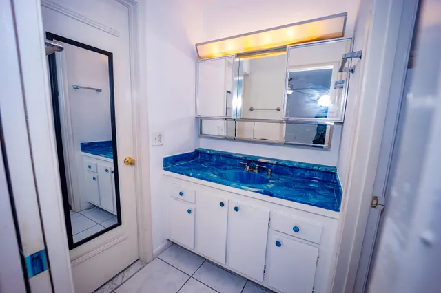 a bathroom with a granite countertop sink and a mirror