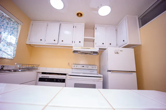 a kitchen with stainless steel appliances granite countertop a refrigerator sink and cabinets