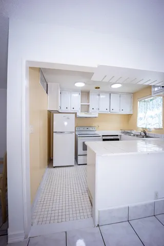 a kitchen with stainless steel appliances granite countertop a refrigerator and a sink