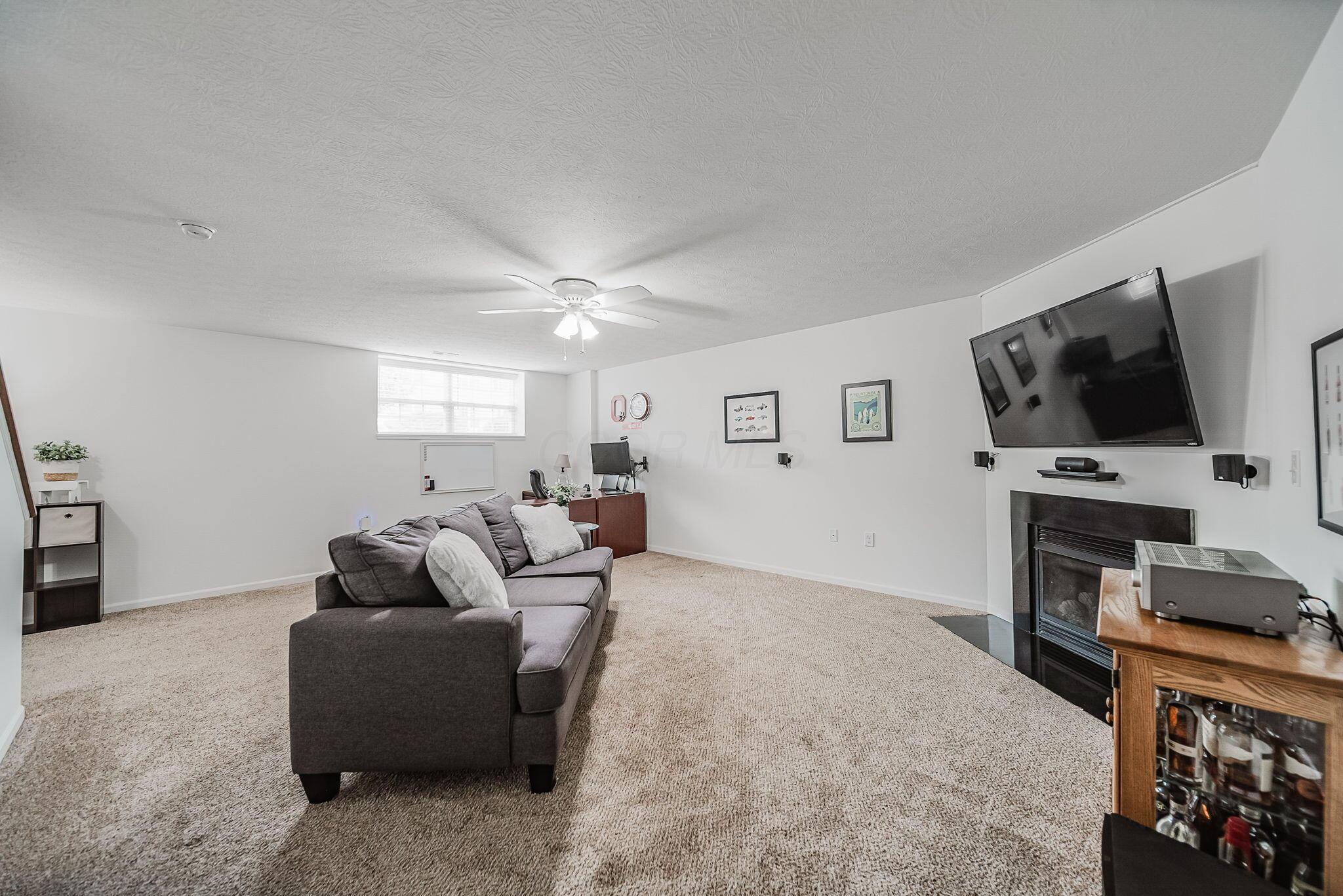 6186 Needletail Road, Unit 66 Columbus, OH 43230 - Photo 26 of 48 Finished lower level with daylight window, neutral decor, overhead lighting, and a cozy gas fireplace make this a beautiful area to spend quality time in for work and play!