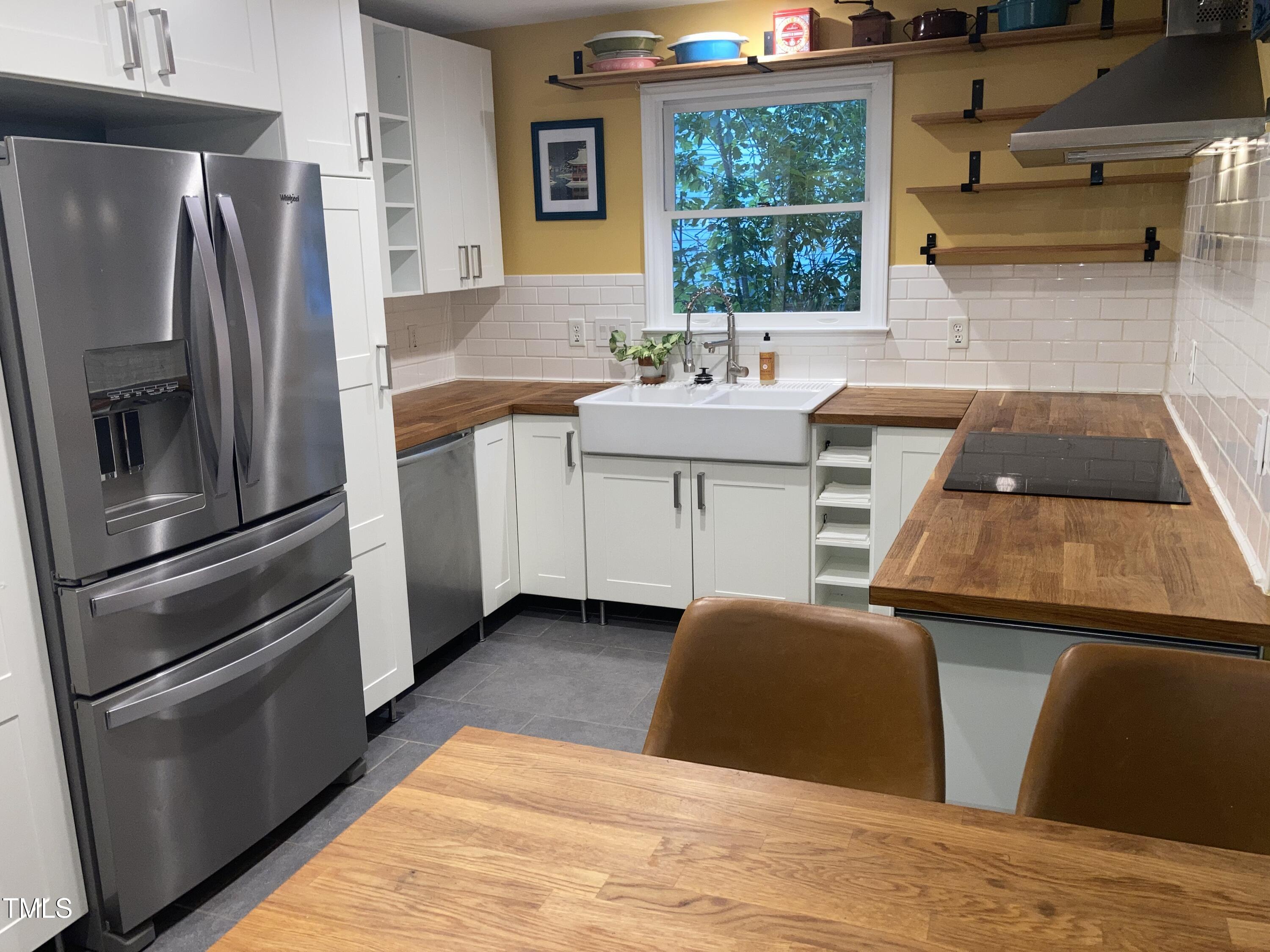5315 Reams Run Road Durham, NC 27713 - Photo 11 of 49 a kitchen with stainless steel appliances kitchen island granite countertop a refrigerator a sink a stove and white cabinets with wooden floor