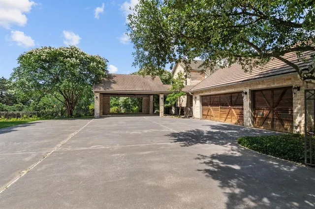 a view of a house with a yard and large tree