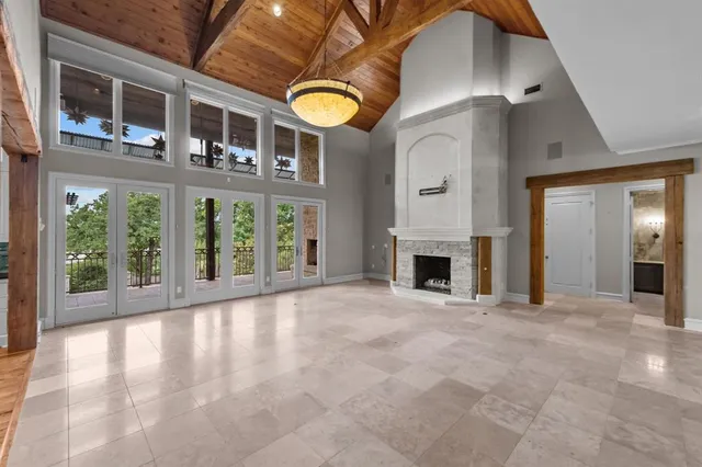 a view of an empty room with a fireplace and a window