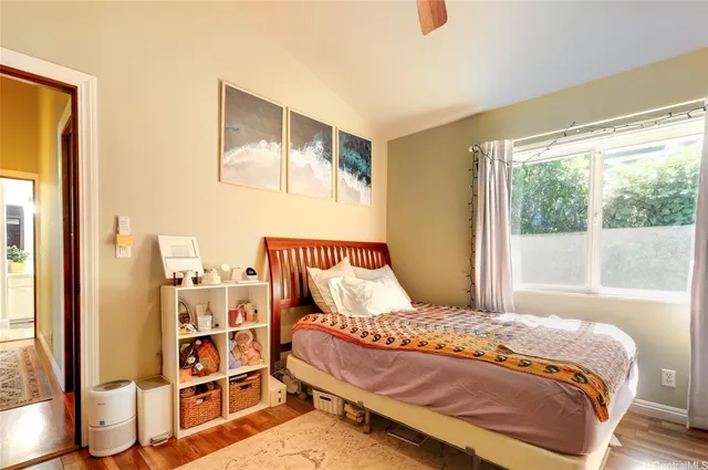 a bedroom with a bed and wooden floor