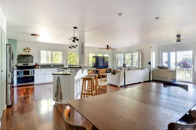 a large white kitchen with lots of counter space and chandelier