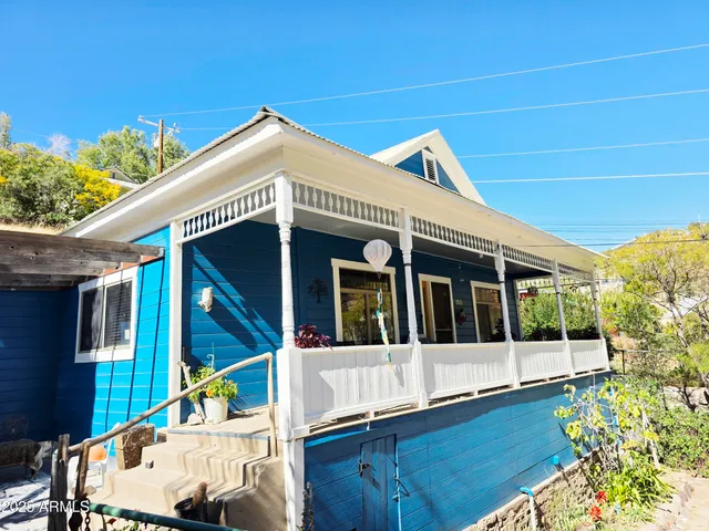 a view of a white house with large windows and a small yard