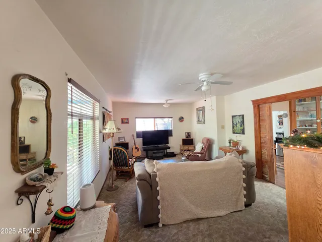 a kitchen with stainless steel appliances granite countertop a dining table chairs refrigerator and sink