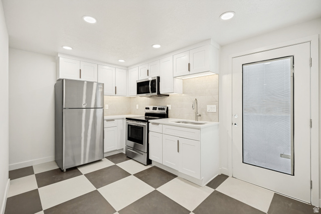 1168 East Center Street Bountiful, UT 84010 - Photo 27 of 38 Modern kitchen featuring white shaker cabinetry, stainless steel appliances, a checkerboard tile floor, and recessed lighting