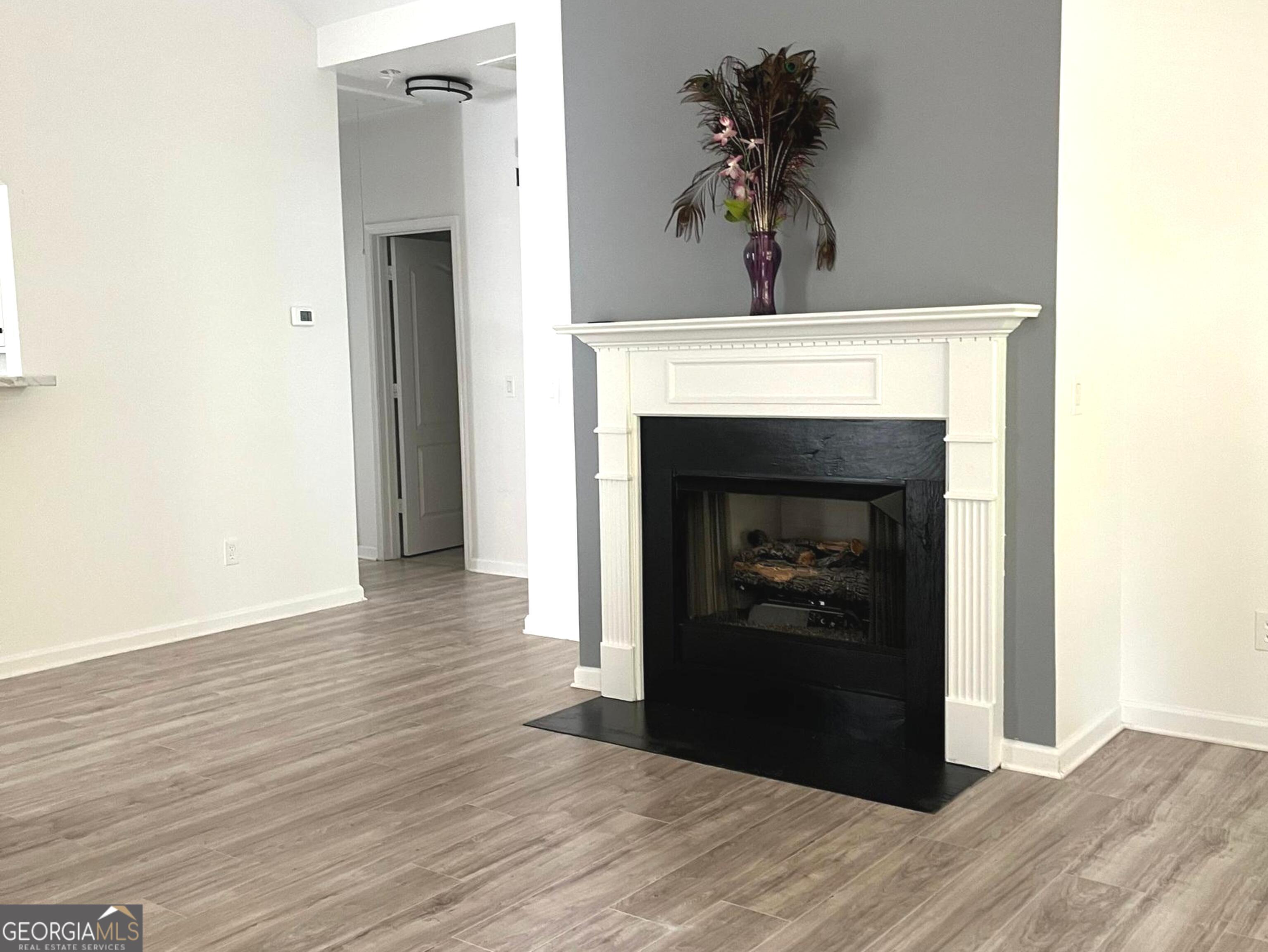 6127 Landers Loop Fairburn, GA 30213 - Photo 5 of 21 a view of an empty room with wooden floor and a fireplace