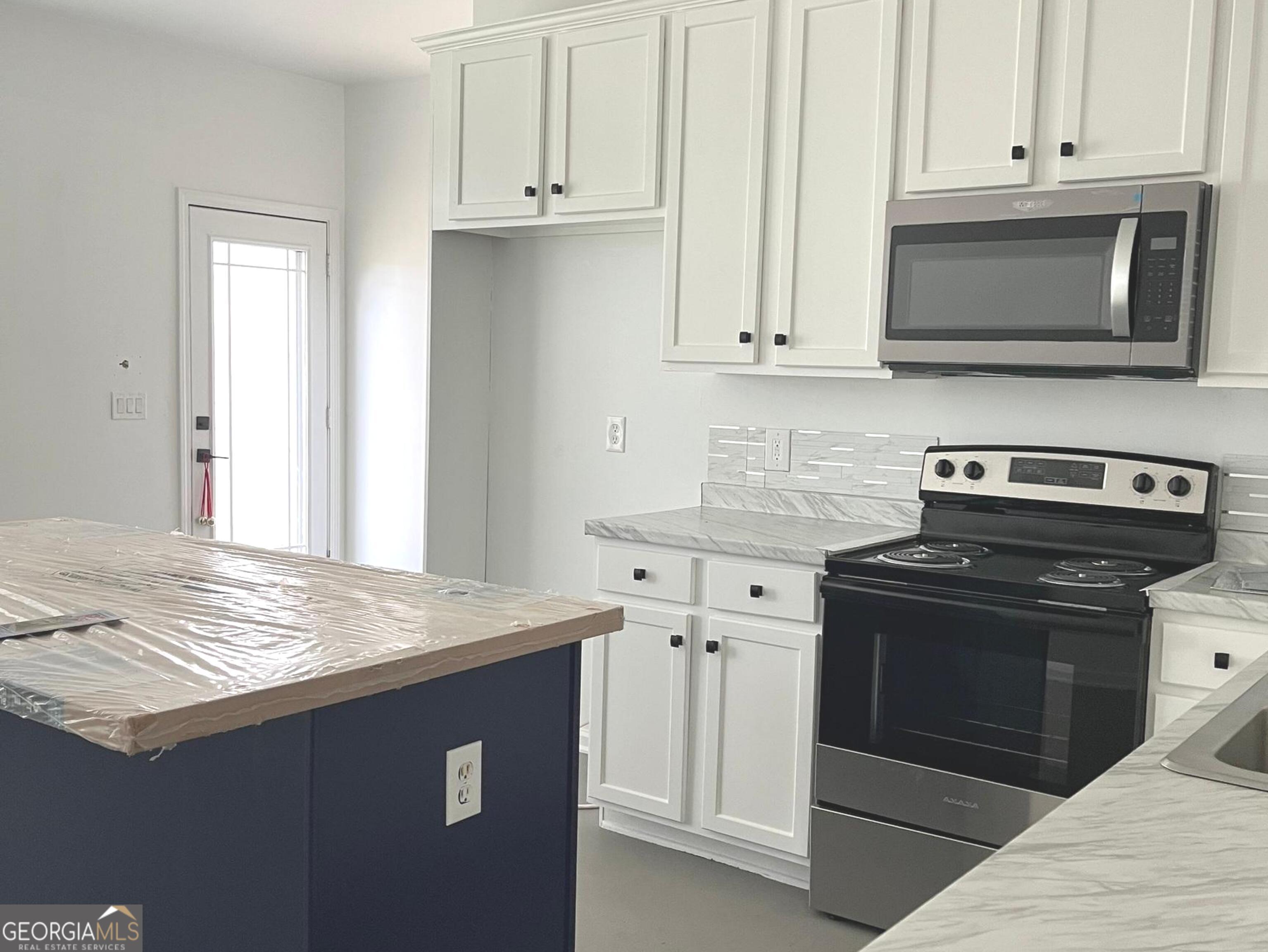6127 Landers Loop Fairburn, GA 30213 - Photo 8 of 21 a kitchen with stainless steel appliances granite countertop a stove a microwave and oven