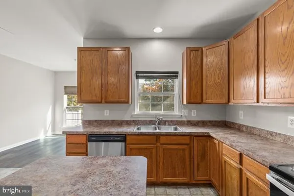 a kitchen with wooden cabinets a sink and a window