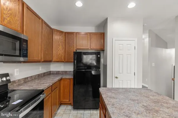a kitchen with granite countertop stainless steel appliances and wooden cabinets