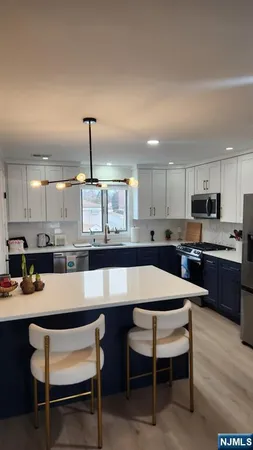 a dining hall with stainless steel appliances kitchen island granite countertop a dining table and chairs