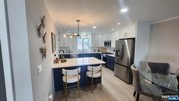 a living room with furniture a rug and kitchen view