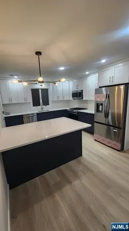 a large kitchen with stainless steel appliances a large counter top