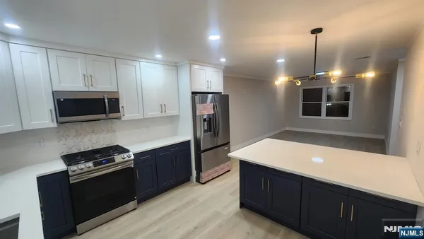 a kitchen with kitchen island a counter space a sink and stainless steel appliances