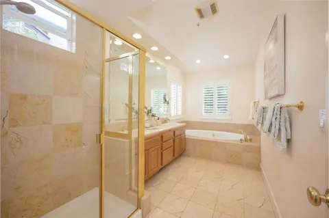 a spacious bathroom with a tub sink and shower