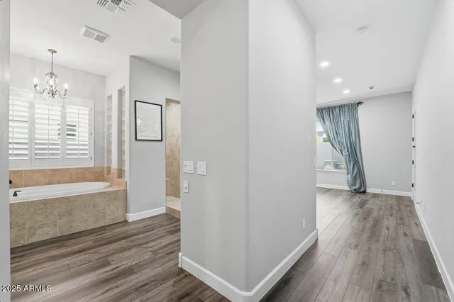 an empty room with wooden floor cabinet and windows