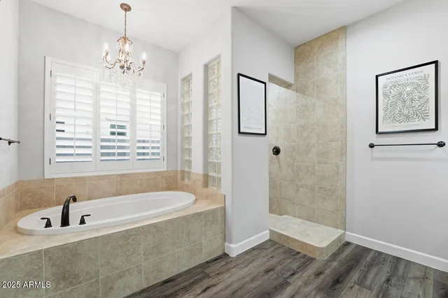 a bathroom with a tub a sink and glass door shower