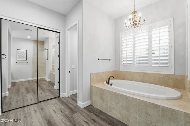 a spacious bathroom with double vanity sink a vanity and a mirror