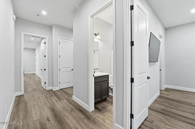a view of an empty room with wooden floor and a window