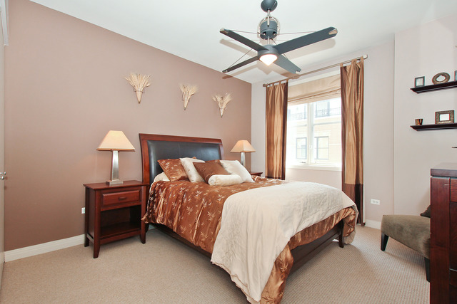 1638 South Indiana Avenue, Unit 4 Chicago, IL 60616 - Photo 12 of 14 a bedroom with a bed chandelier and a window