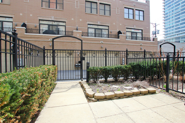 1638 South Indiana Avenue, Unit 4 Chicago, IL 60616 - Photo 9 of 14 a view of a building with a small yard and plants