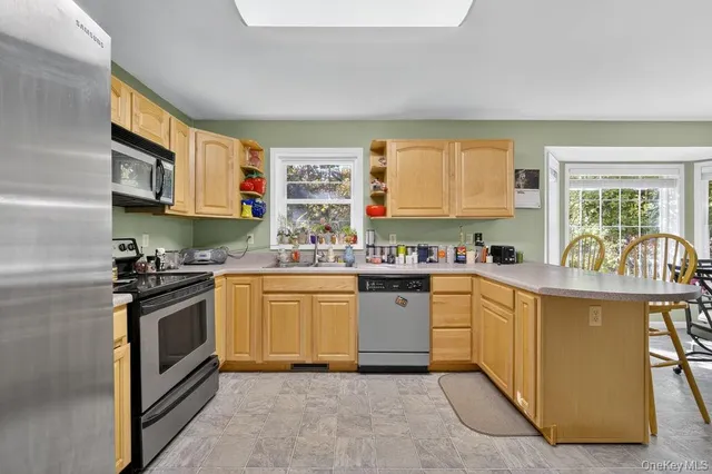 a kitchen with stainless steel appliances granite countertop a stove a sink and a microwave