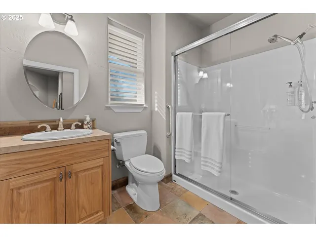 a spacious bedroom with a bed a chandelier and a dresser