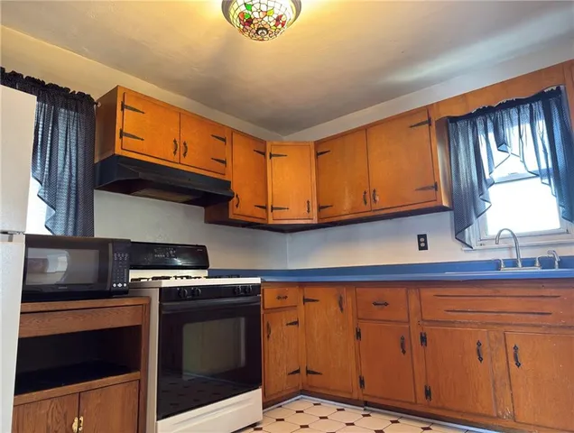 a kitchen with granite countertop cabinets stainless steel appliances and a window